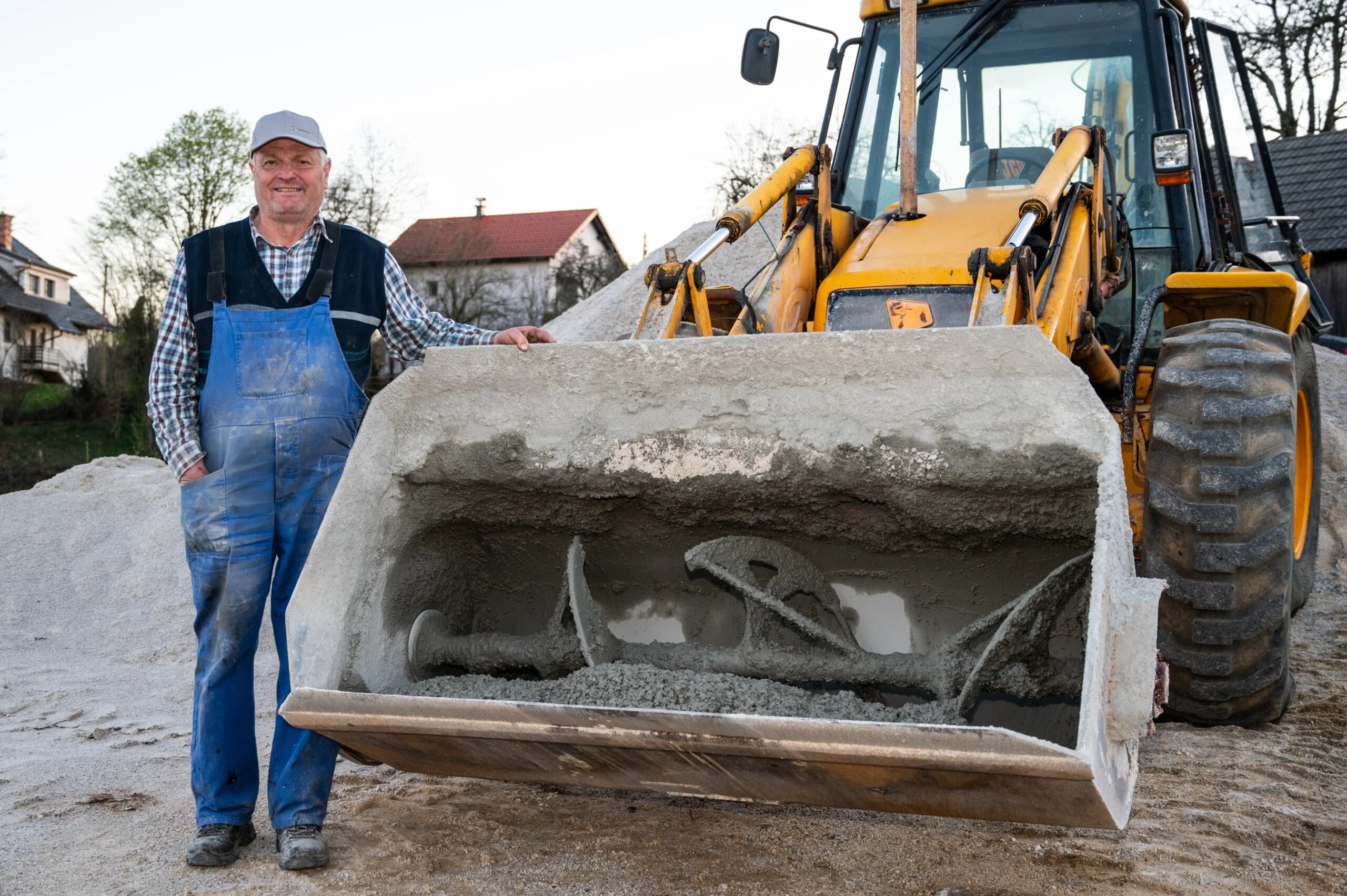 vinko-2-scaled Man, mister Vinko Pirc, standing next to mixing bucket with spiral attached to JCB backhoe loader.